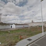 Vista de nave industrial con grúa en exterior y zona de obra en polígono